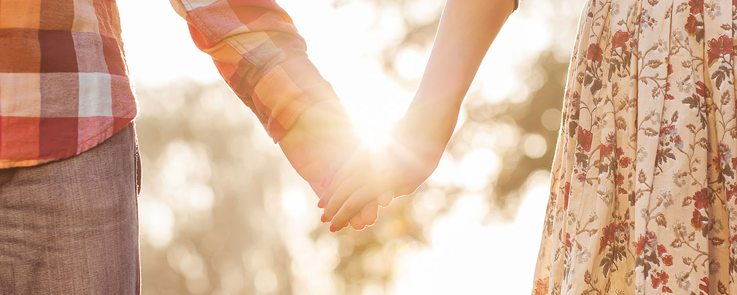 A couple holding hands in the sun